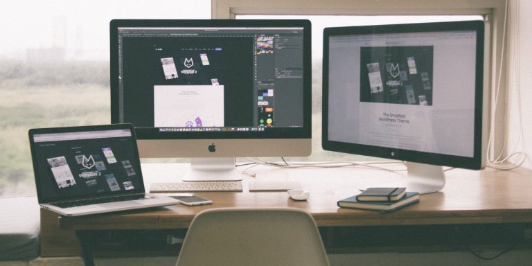 Two Macs And A Macbook On A Desk.jpg