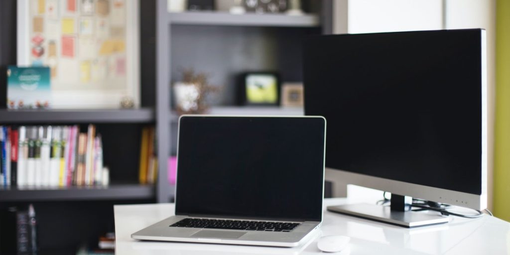 A Laptop And A Desktop Computer Are On A White Desk.jpg