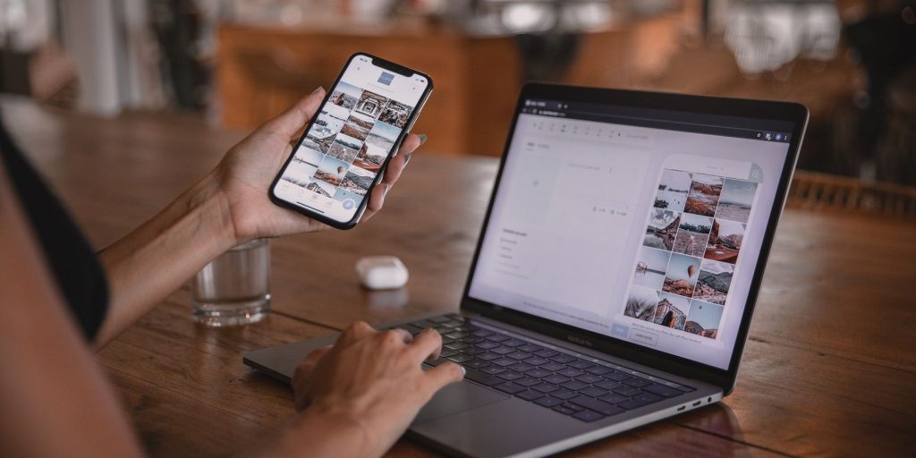 A Person Using A Smartphone Working On A Laptop.jpg