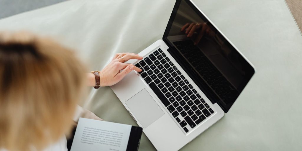 A Woman Uses A Laptop On A White Leather Couch.jpg