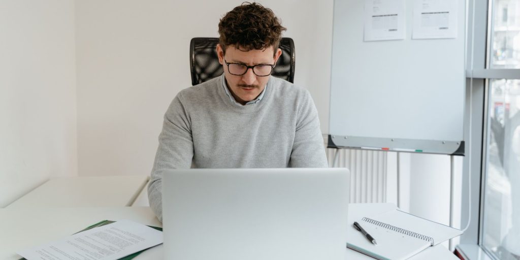 Man in gray sweater working on laptop.jpg