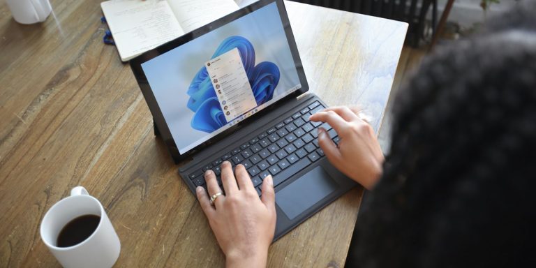 A Person Using A Windows Pc On A Brown Desk.jpg